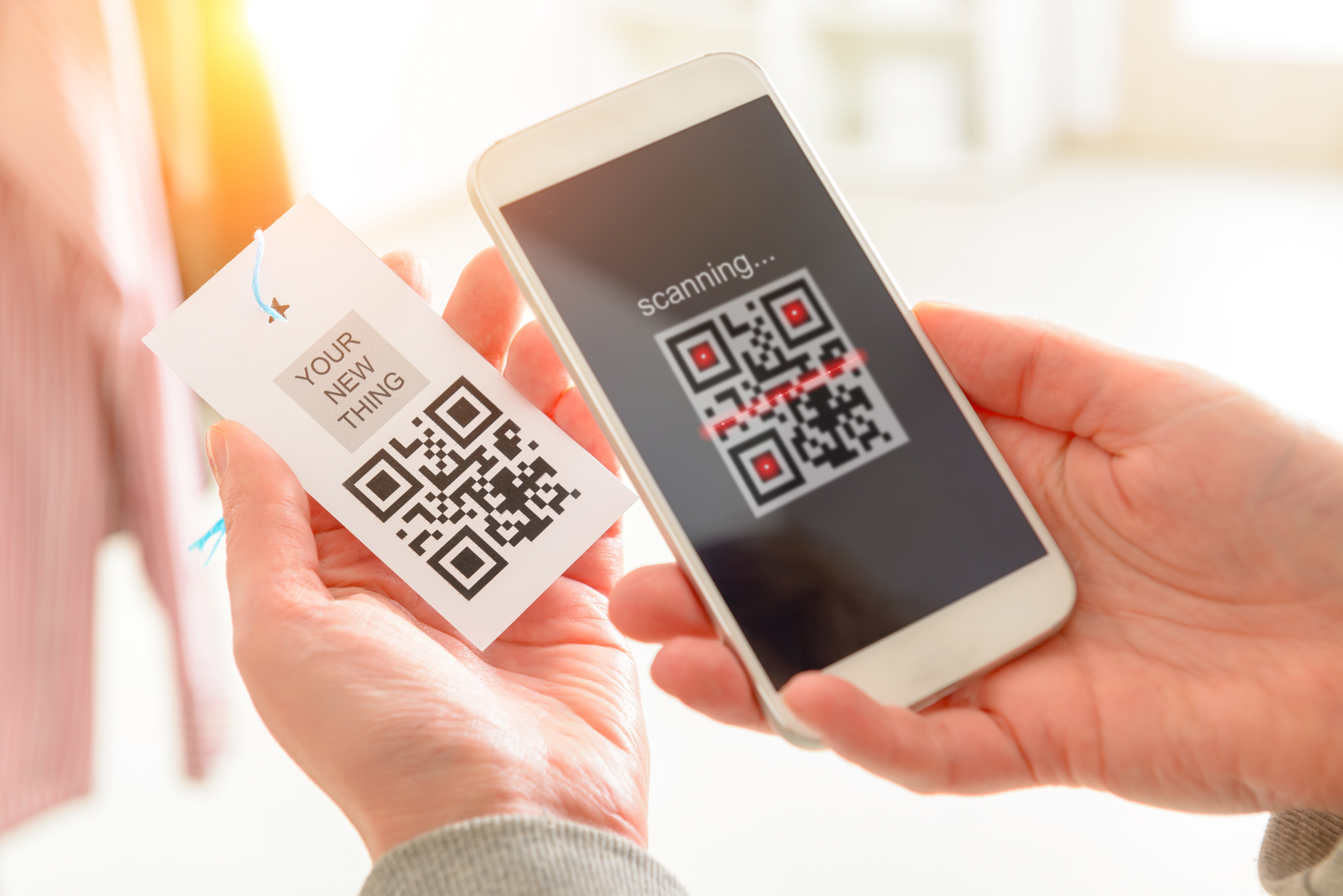 Woman scanning QR code QR Code auf Etikett wird mit Smartphone gescannt